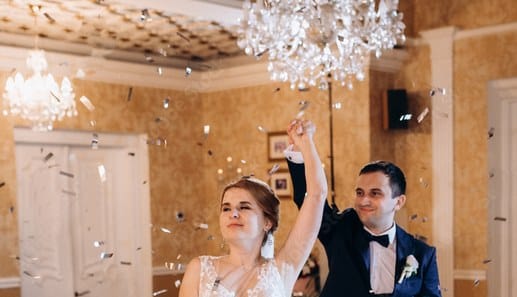 Bride and groom in a chandelier-lit ballroom