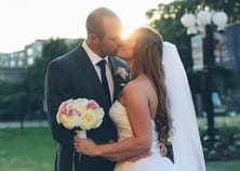 Bride and groom kissing with a bouquet
